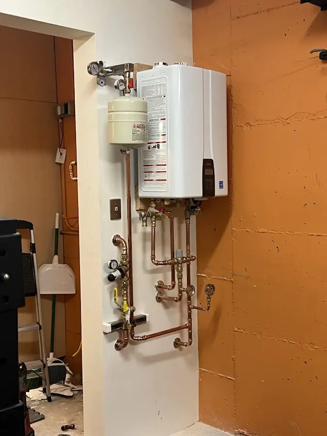 Plumbing technician inspecting water heater connections in Reston